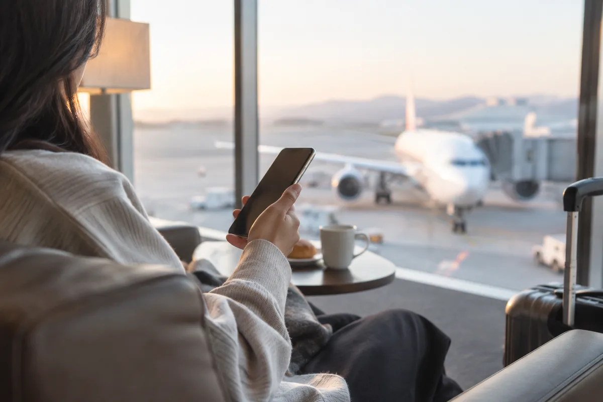 공항 대기 공간에서 스마트폰을 확인하는 여행자